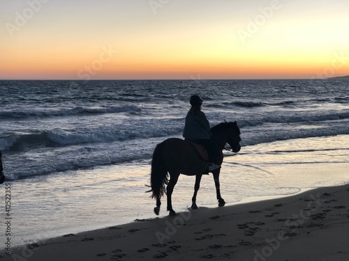 Mujer dando un paseo en caballo por la orilla de la playa en Tarifa, Cádiz