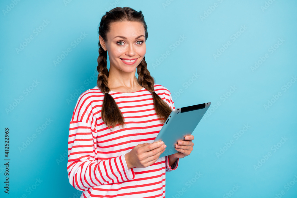 Photo of cute charming young woman dressed striped shirt reading modern device isolated blue color background Photo of cute charming young woman dressed striped shirt reading modern device isolated blue color background