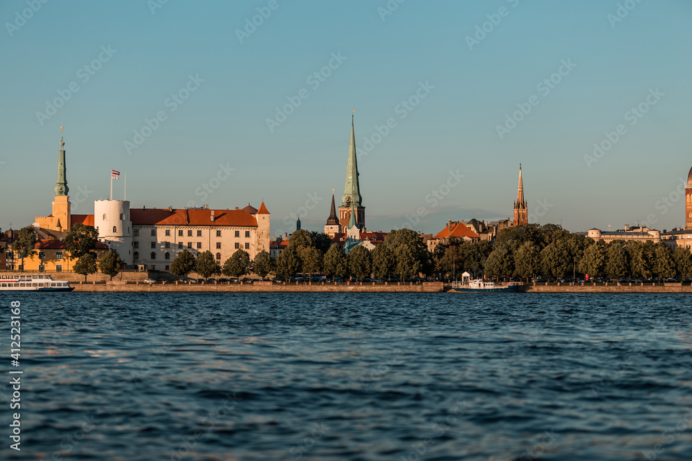 Riga old town in Latvia, Europe, view from the water in summer, golden hour