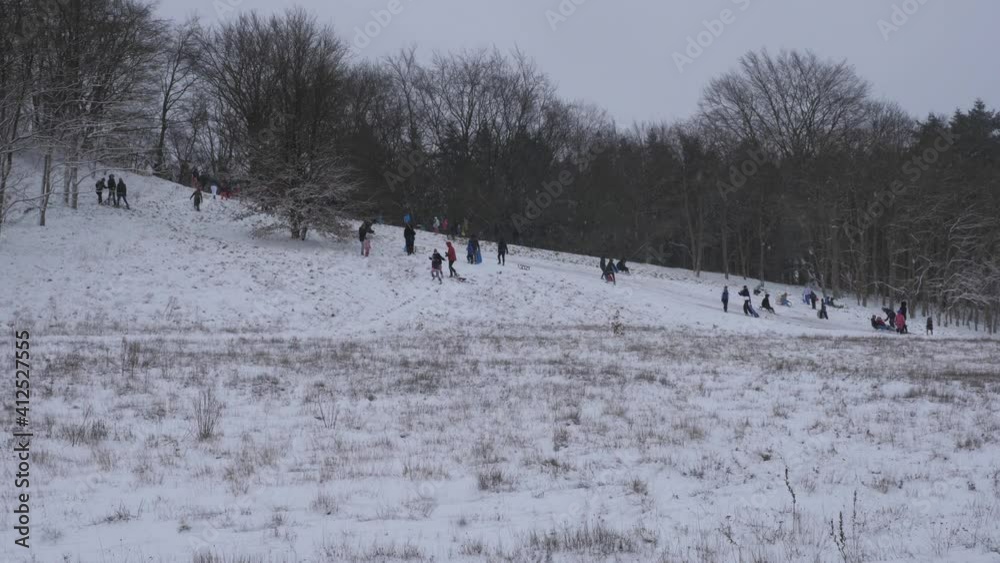 Netherlands - 8 january 2021, Hilversum: People are sledding of a snowy hill in winter time Netherlands - 8 january 2021, Hilversum: People are sledding of a snowy hill in winter time
