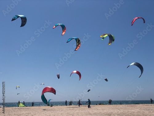 cometas de kitesurf de colores en la playa de Tarifa con el cielo azul