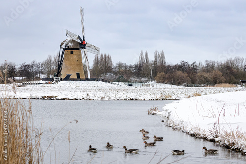 Historic windmill in a winter landscape with snow in Holland photo