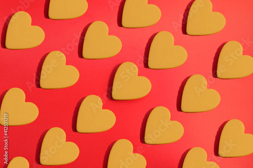 pattern of yellow hearts on a red background with bright light. creative idea with heart. love concept