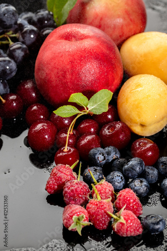 Summer fresh berries and fruits on black background