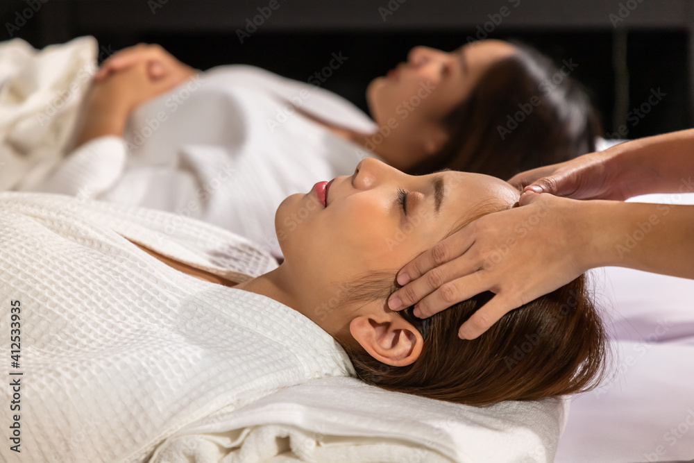Beautiful young Asian woman enjoy head massage in tranquil spa salon, with candle. Beautiful young Asian woman enjoy head massage in tranquil spa salon, with candle.