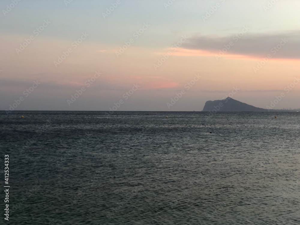 Atardecer con el cielo anaranjado y rosado en la playa cerca del mar Atardecer con el cielo anaranjado y rosado en la playa cerca del mar
