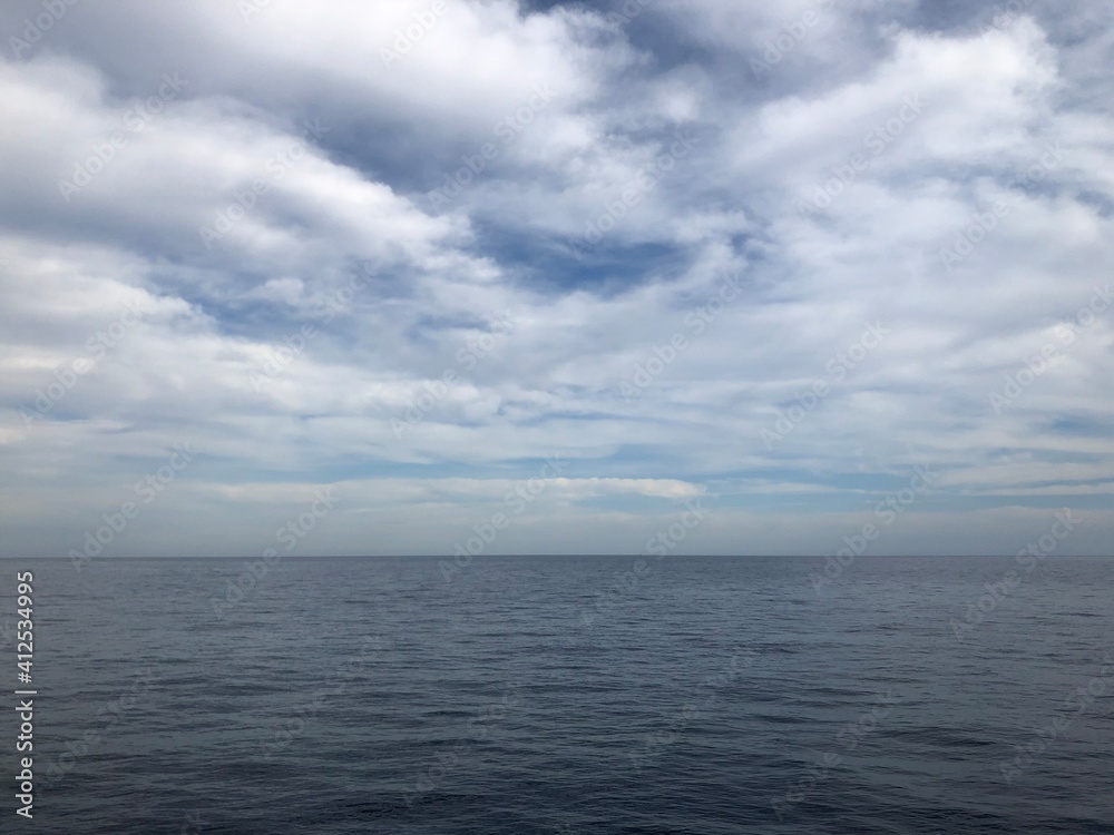 Fondo de mar Mediterráneo con el cielo lleno de nubes blancas