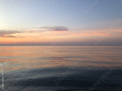 Atardecer con el cielo anaranjado y rosado en la playa cerca del mar