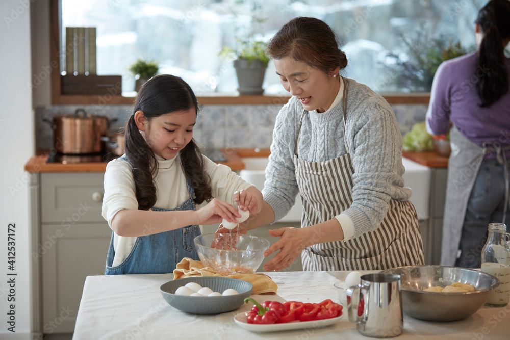 Happy adorable little child girl in apron enjoying cooking homemade pastry together with family at home. Happy adorable little child girl in apron enjoying cooking homemade pastry together with family at home.