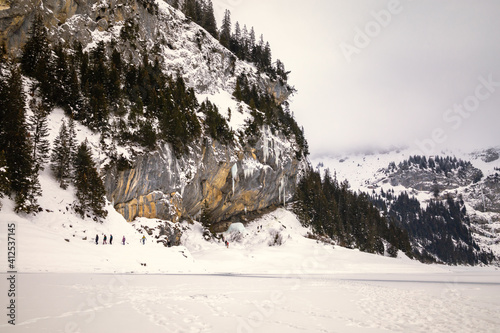 Wallpaper Mural Group of people walking next to a frozen lake in snowy mountain landscape Torontodigital.ca