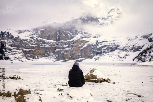 Wallpaper Mural Woman sitting on a frozen lake in snowy mountain landscape Torontodigital.ca