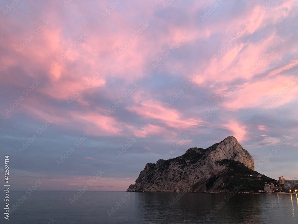 Atardecer con el cielo rosado, el mar y el peñón de Ifach en Calpe, Alicante