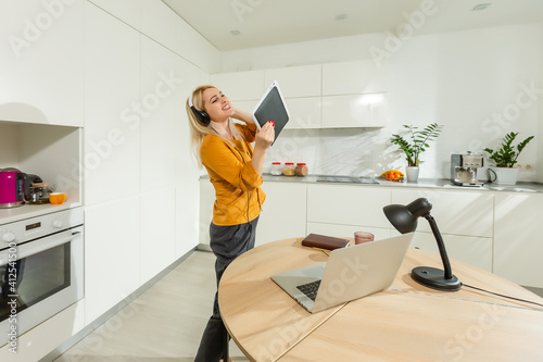 Portrait of woman working with laptop in bright kitchen. Covid-19 coronavirus. Social distancing