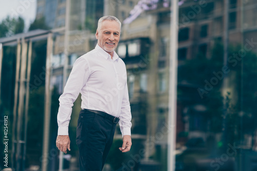 Profile photo of optimistic grey hair old business man going wear white shirt outdoors near work center