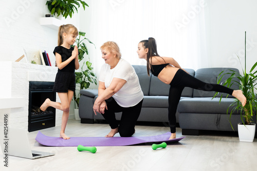 grandmother and children exercising workout at home near the window in room