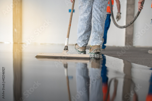 Worker working on the floor of an industrial building with special shoes to avoid damaging the floor.