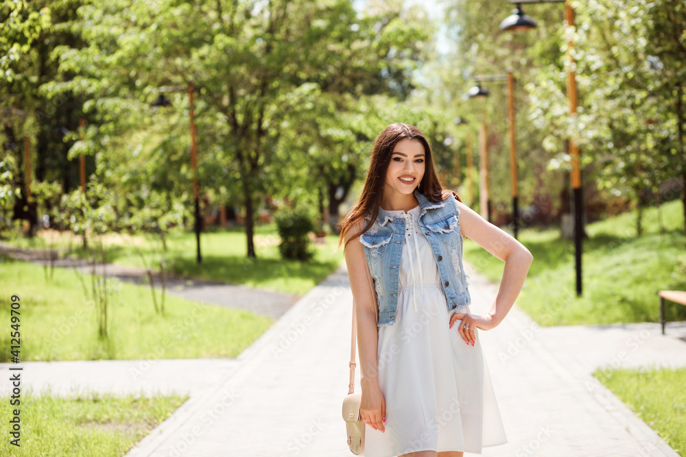 Fashionable woman spending time outdoors in the park in summer. Fashionable woman spending time outdoors in the park in summer.