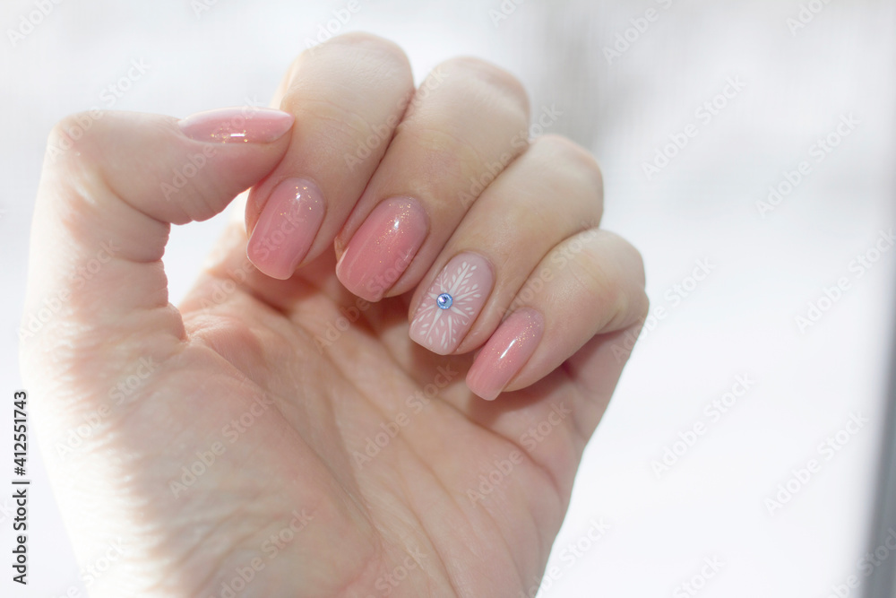 Winter manicure on nails against the background of a winter window Winter manicure on nails against the background of a winter window