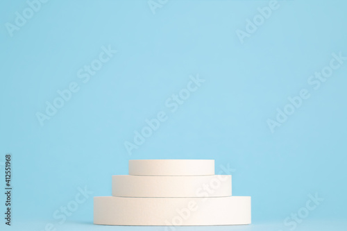 Beauty products background. Beige cylinders on blue background with copy space. Product podium stand, trendy minimal geometric scene © studiomay