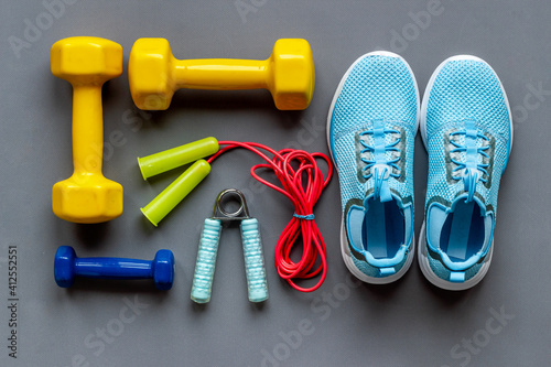 Athlete set of sneakers and bottle of water on bright blue background