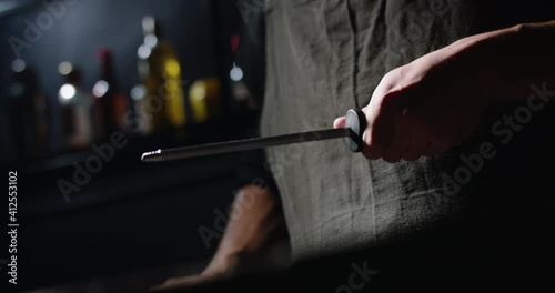 Close-up shot of chef sharpens knife for cooking, chef preparing his knife