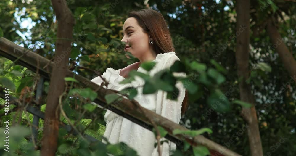 Woman stands and looks around inside orangery. Woman stands and looks around inside orangery.