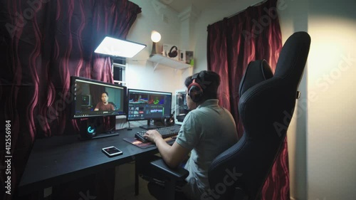 Young man editing video in computer. Videographer, video editor, content creator in creative industry.