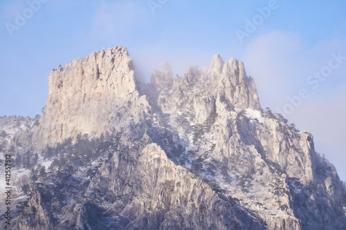 rocky peak of Mount Ai-Petri against the sky in bright sunlight through a cloudy haze