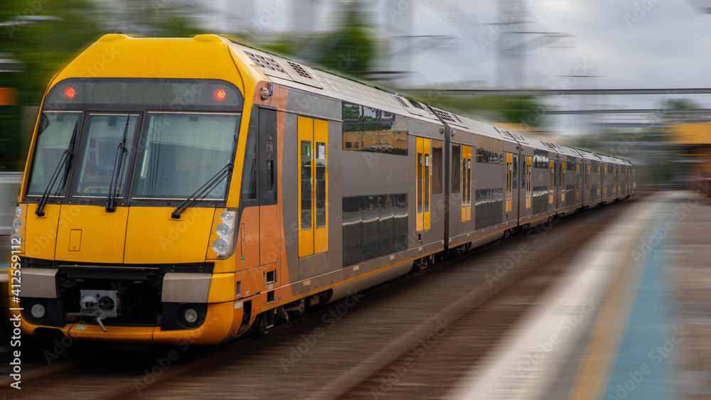 Naklejka premium Commuter Train fast moving through a Station in Sydney NSW Australia