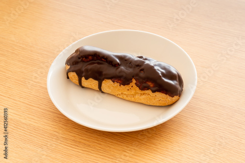 Foto A chocolate eclair on a white dish