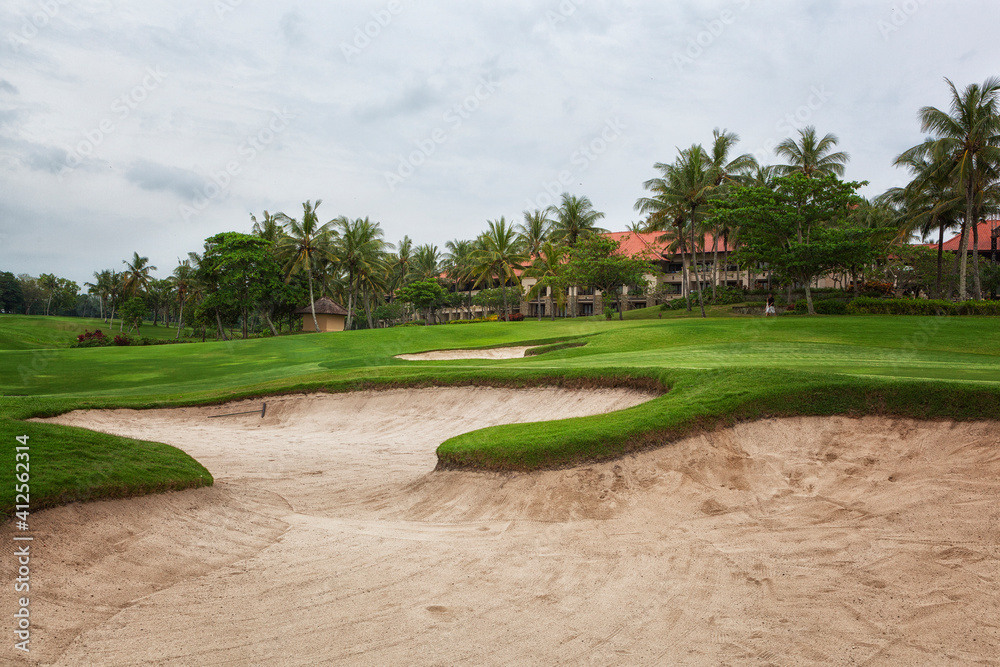 Obraz premium Golf course with palm trees over blue cloudy sky