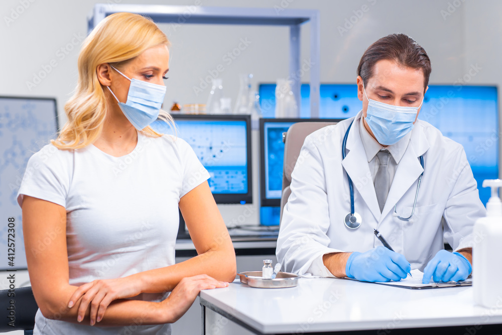 Professional doctor makes a coronavirus vaccine using a syringe and hypodermic needle. Professional medical worker and patient at the hospital office. Vaccination and safety. Professional doctor makes a coronavirus vaccine using a syringe and hypodermic needle. Professional medical worker and patient at the hospital office. Vaccination and safety.