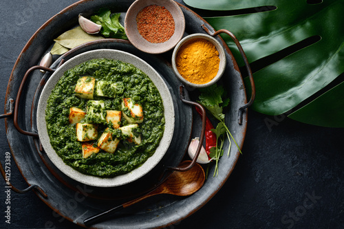 Palak Paneer indian traditional food with cheese and spinach on black background, view from above photo