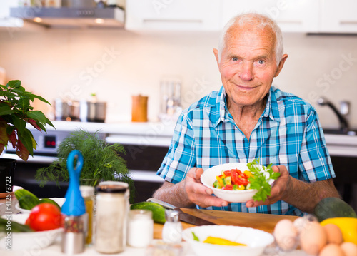 elderly man made a fresh vegetable salad at home