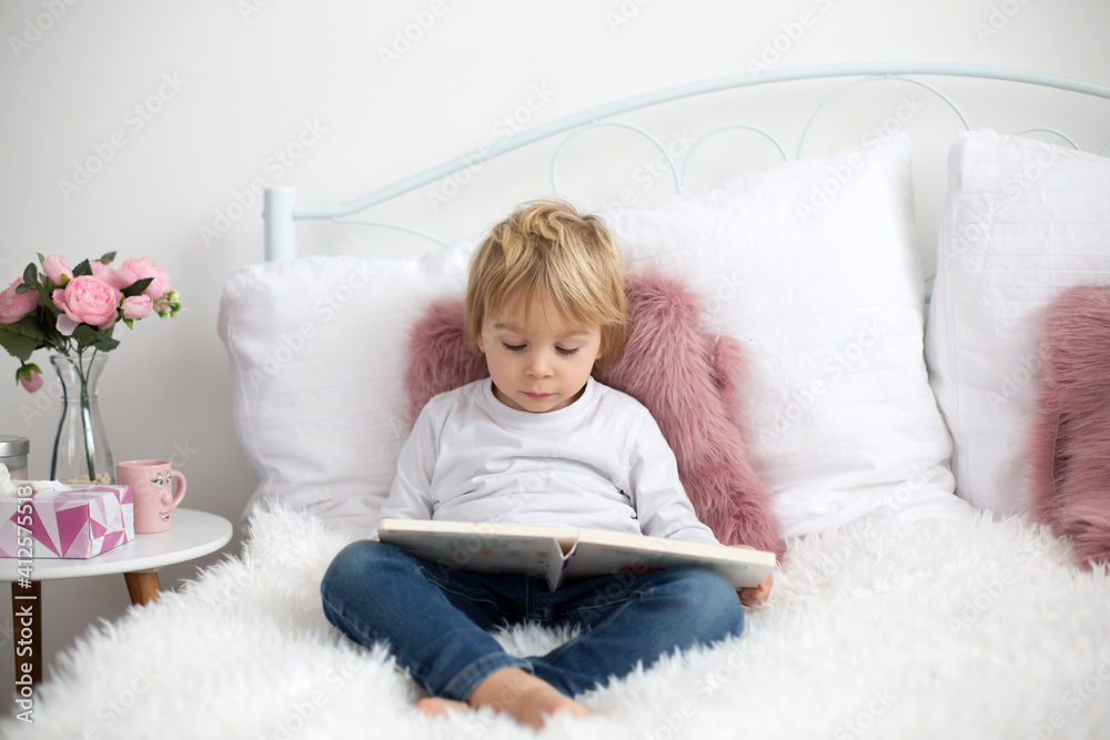 Cute child, lying in bed, reading book Cute child, lying in bed, reading book