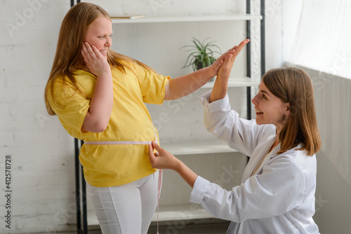 Nutritionist and fat girl celebrating first good results of a diet