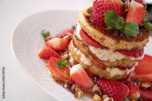 Food photography of a french toast sandwich with cream and strawberries.