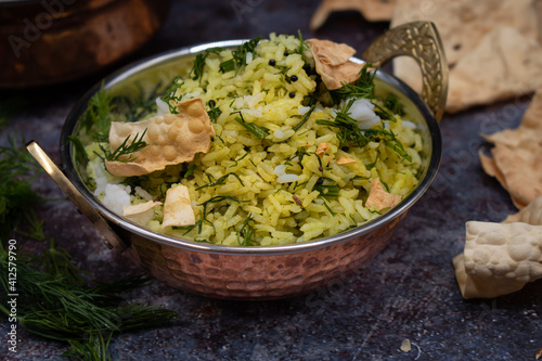 Vegan Indian dill rice and papad served in traditional hammered bowl