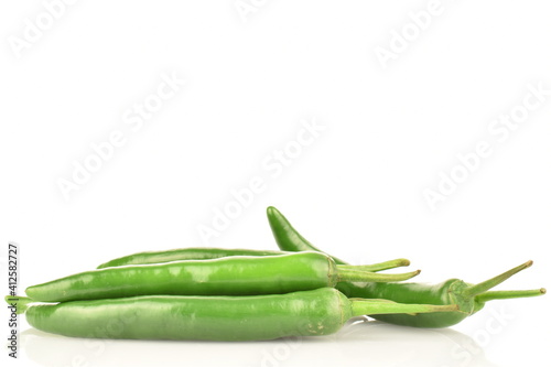 A few pods of ripe organic, spicy green hot pepper, close-up, on a white background.