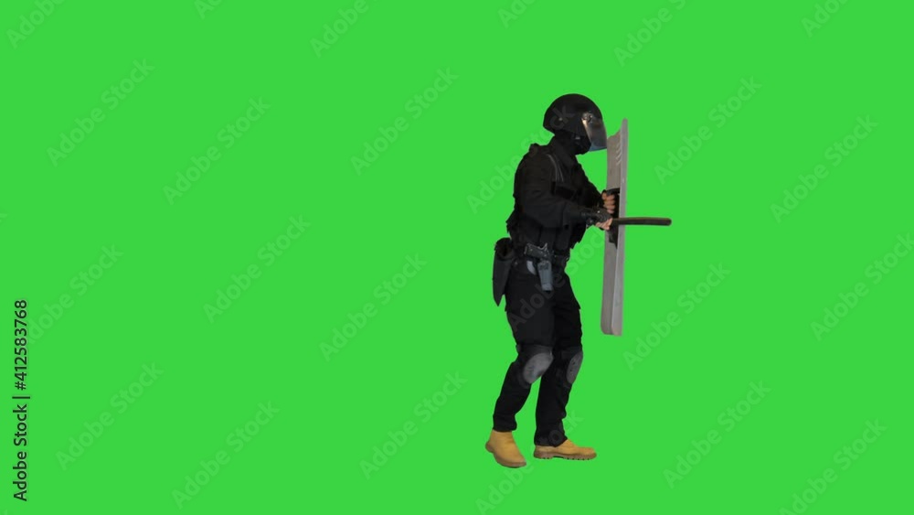 Riot police officer hitting his riot shield while moving forward with ...