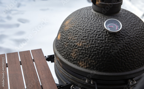 Winter bbq in the fresh white snow, Men grilling chicken wings in the winter onn grill photo