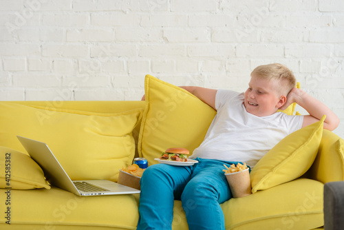 Slika na platnu Obese boy having fun while watching a movie
