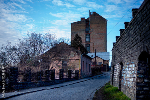 staninny town street, mystical cityscape, old paving stone in a European city, facades of stone houses