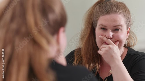 [4k] chubby woman looking at self at mirror thinking before having an idea