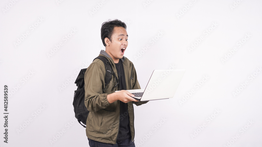 The young man wearing bag shouting and yelling on a white background with laptop The young man wearing bag shouting and yelling on a white background with laptop