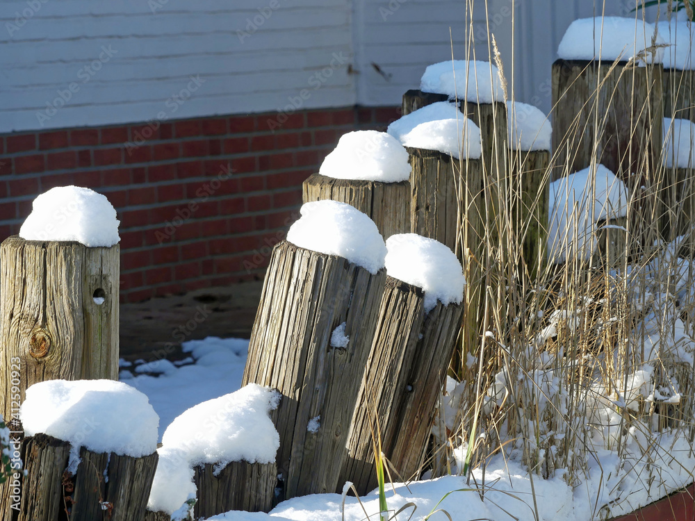 Holzpfähle mit Schneehaube