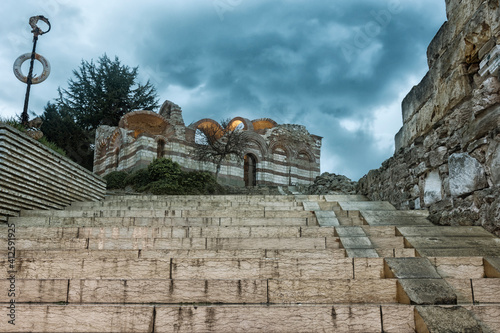 Ruins of Church of St. John Aliturgetos, located in the UNESCO – protected ancient town of Nessebar. Dark cloudy stormy weather. Tourism concept. photo