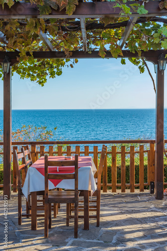 Cosy restaurant's garden with sea view in the ancient town of Nessebar, Bulgaria. UNESCO - protected. Tourism concept. Wooden furniture.  Lifestyle concept. Interior