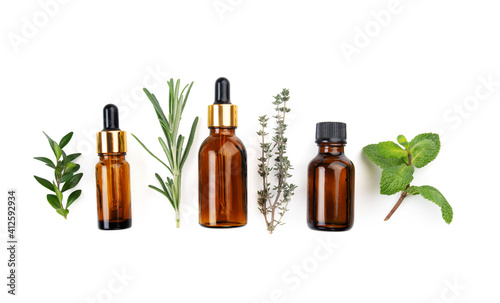 Fototapeta Naklejka Na Ścianę i Meble -  Dropper bottles with oil and herbs on white table flat lay view. Herbal cosmetics concept