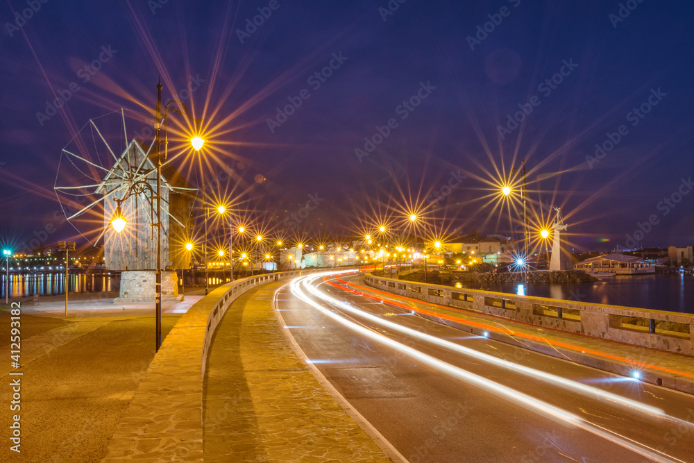 Old windmill and light trails motion of the passing by cars. Long exposure view of the windmill, located on a narrow man-made isthmus at the entrance of the UNESCO - protected ancient town of Nessebar